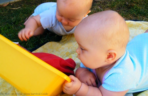 Infants extend tummy time with a simple cloth napkin sensory bin for babies. Great for exploration, fine motor and gross motor development in infants.