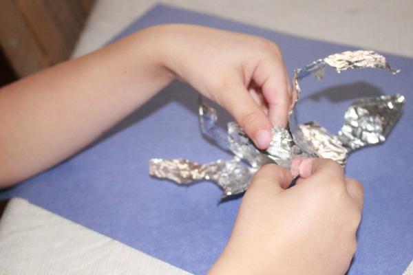 What a fun indoor activity for winter time! Kids can paint foil snowflakes. This simple snowflake foil craft combines cutting, painting and fine motor skills for preschool. 