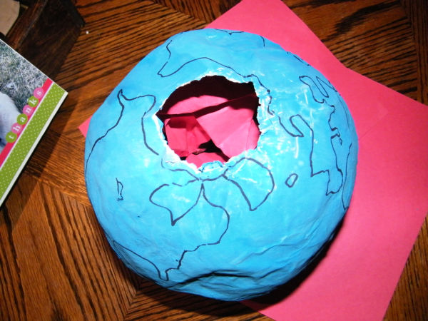 Crumpled up red paper is stuffed into the globe to represent the molten rock.