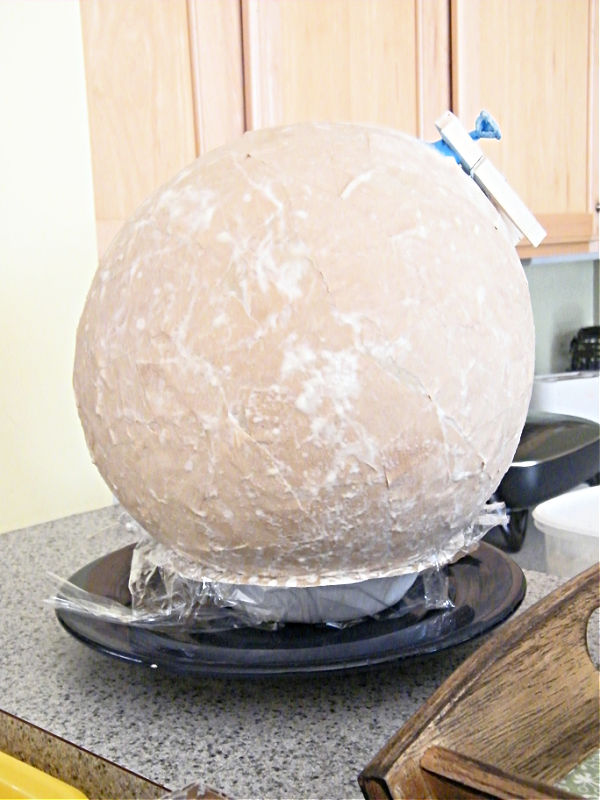 Adding papier mache to a balloon to make a diy globe model for kids.