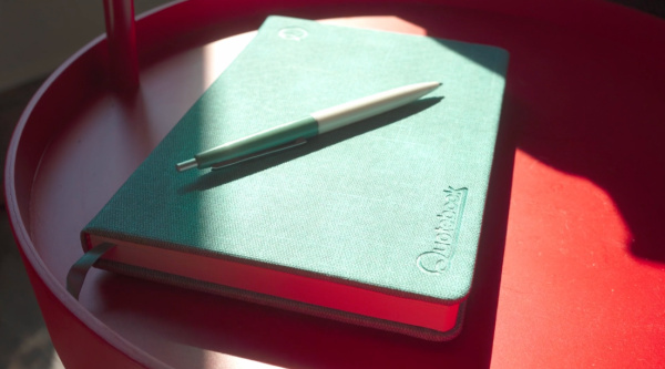 Quotebook on a table with a pen ready for use to record the small memories to save forever.