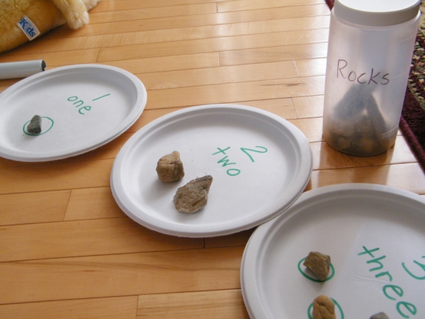Rock collection and paper plate preschool counting and fine motor activity supplies.