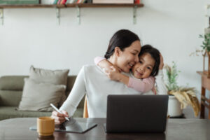 Mom with child as she works from home to support her family as a stay at home mom.