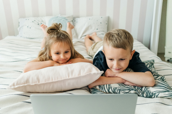 Two kids watch ono a laptop. Stories of a Lifetime is a video based service that captures your families memories and preserves them for your children to watch. This is a great way to capture and share family stories and memories.