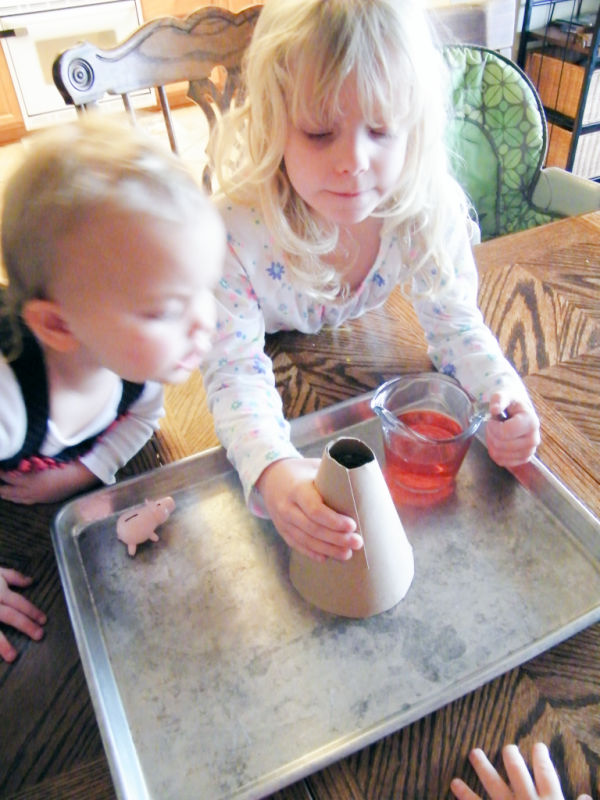 Preschooler and toddler looking at the volcano experiment.