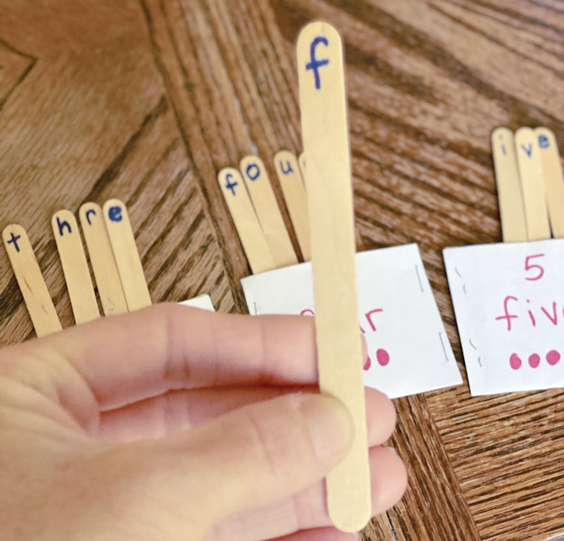 Labeled craft sticks and index card pockets to spell number words in a hands-on way.